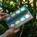 suva beauty's toppers holographic highlight and glow palette shot in a tropical forest