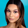 model wearing the suva beauty hydra fx color 'doodle delish' (purple and pink) as a graphic eyeliner shown in daylight
